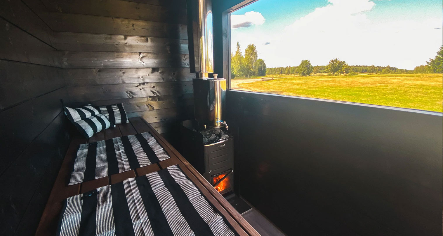 TäsmäSauna Maisema -saunavaunun näkymä sisältä. Lauteet ja Harvia-kiuas.